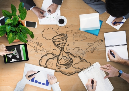 Digital composite of Overhead of hands writing with wood panel and hourglass doodle