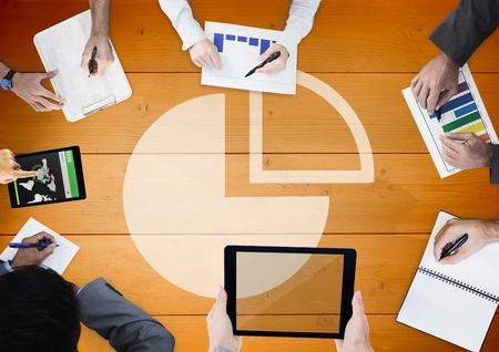 Digital composite of Overhead of business team with orange wood panel and pie chart graphの写真素材