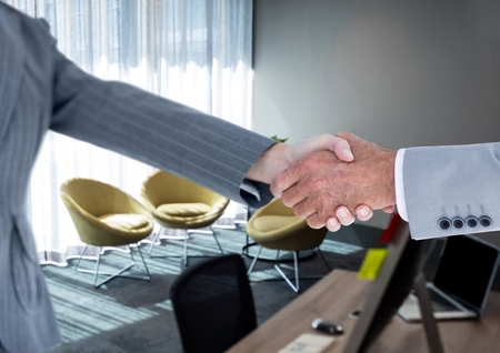 Digital composite of handshake in the desk of the officeの写真素材