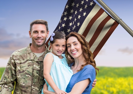 Digital composite of soldier with family in front of usa flag in the fieldの写真素材