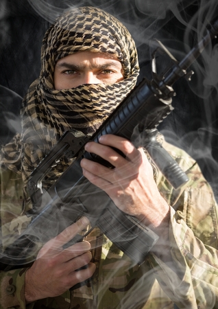 Digital composite of soldier with face covered and weapon in his hands, looking us. smoke around him. black backgroundの写真素材