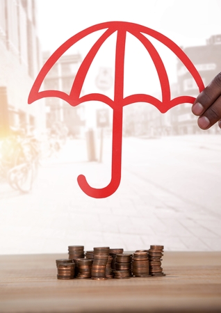 Digital composite of Cut out umbrella over money coinsの写真素材