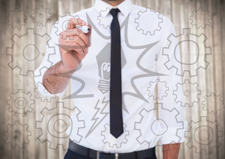 Digital composite of Business man mid section writing lightbulb and cog  doodles against blurry wood panelの写真素材
