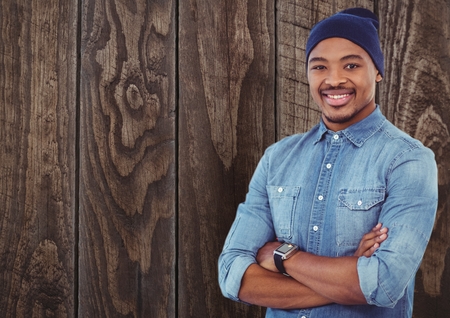 Digital composite of Casual man with wooly hat standing on ahead a wood wallの写真素材