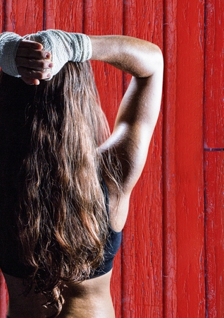 Digital composite of fitness woman backs with red wood backgroundの写真素材