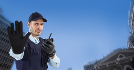 Digital composite of Portrait of security guard showing stop gesture while holding walkie talkie in...