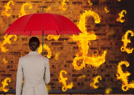 Digital composite of Digital composite image of businesswoman holding red umbrella looking at burning symbol of poundsの写真素材