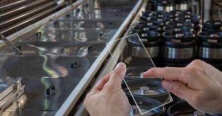 Digital composite of Hands taking picture of containers through transparent device at breweryの写真素材