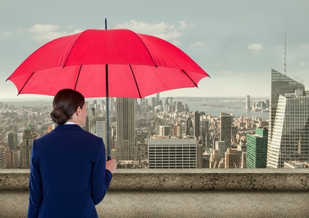 Digital composite of Rear view of businesswoman holding red umbrella while looking at cityの写真素材