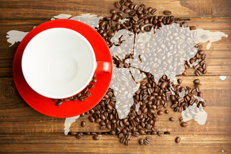 Silhouette of the world against coffee beans and cupの写真素材