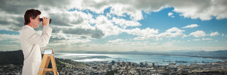 Businessman looking on a ladder against landscape of city and cloudy sky