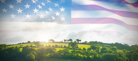 Pole with waving flag of America against country scene