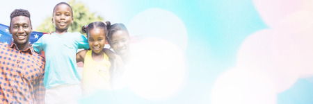 Portrait of happy family with American flag on sunny day at parkの写真素材