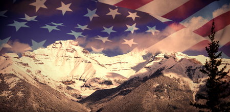 Close up of the us flag against scenic view of snowy mountain rangeの写真素材