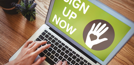 Sign Up Now text with icons on green screen against hands of woman using laptop