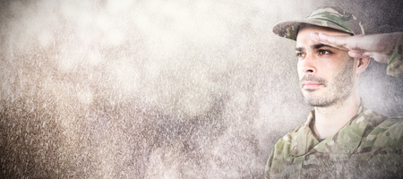 Close up of confident soldier saluting against dark backgroundの写真素材