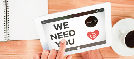 We Need You text with icons on screen against hands holding blank screen tabletの写真素材