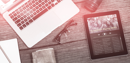 Music app against close up of laptop with camera and digital tablet on tableの写真素材