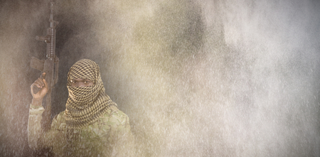 Portrait of face covered soldier holding rifle against black