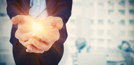 Womans hands cupped  against digital image of laptop on table against adhesive notesの写真素材