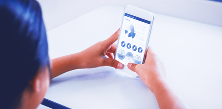 Blue graphics on white background against woman using phone at tableの写真素材