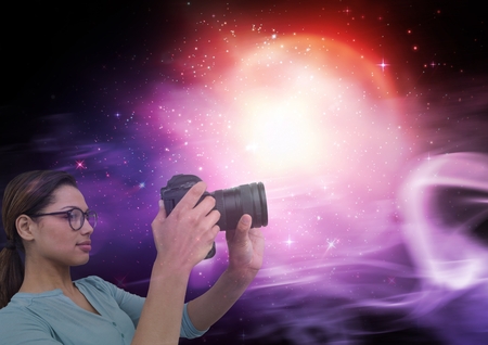 Digital composite of Photographer taking pictures against galaxy background