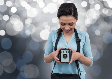 Digital composite of happy photographer with vintage camera. Silver bokeh behindの写真素材