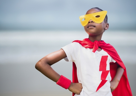 Digital composite of Girl superhero against blurry beachの写真素材