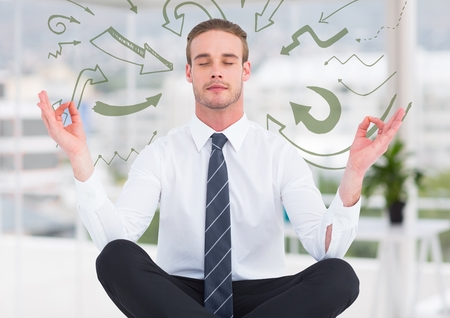 Digital composite of Business man meditating in blurry white office surrounded by 3D green arrow doodlesの写真素材