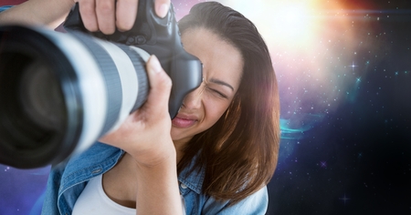 Digital composite of Photographer taking pictures against galaxy background