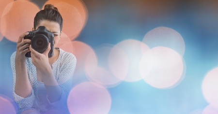 Digital composite of Photographer taking pictures against glowing backgroundの写真素材