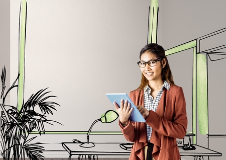 Digital composite of young businesswoman smiling with tablet in front of the blueprint of the new officeの写真素材