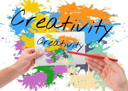 Digital composite of creativity (text with colors). Background+ hands drawing it on a paper