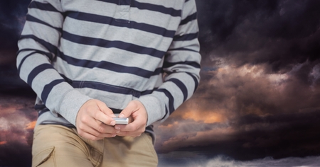 Digital composite of Part of a man texting in darkness
