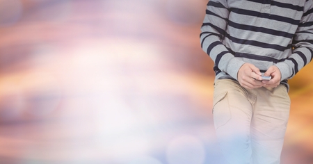 Digital composite of Part of a man texting in colored lights background