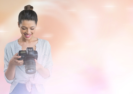 Digital composite of Smiling photographer looking at her camera in fogの写真素材