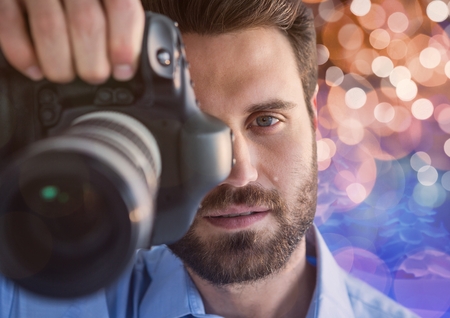 Digital composite of photographer foreground taking a photo with reflex. Blurred  brown and blue...