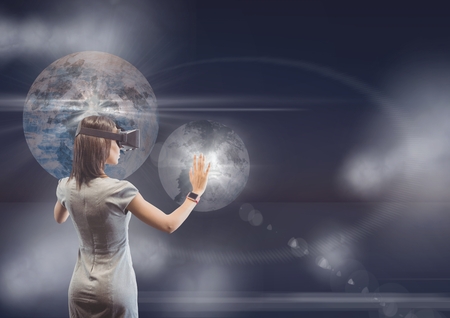 Digital composite of Woman in VR headset touching 3D planets with flares against purple background