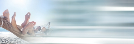 Digital composite of Couple in hamoc at beach with blurry grey transitionの写真素材