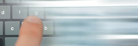Digital composite of Finger typing on keyboard with blurry grey transitionの写真素材