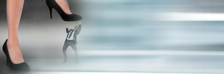 Digital composite of Business man being stepped on by giant feet with blurry grey transitionの写真素材