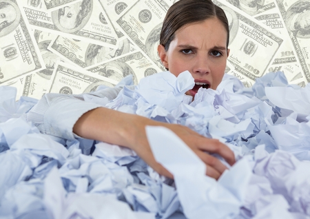 Digital composite of Woman covered in crumpled paper against money backdropの写真素材