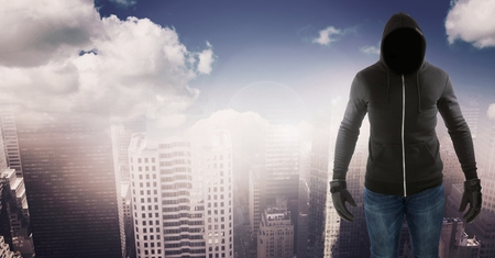 Digital composite of anonymous criminal in cityscapeの写真素材