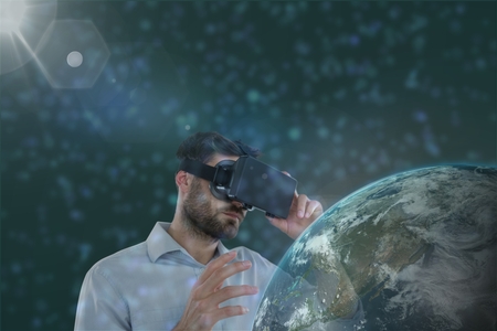 Digital composite of Man in VR headset looking to a 3D planet  against green background with flaresの写真素材