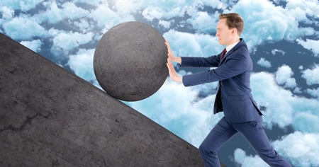 Digital composite of Man pushing rolling round rockの写真素材