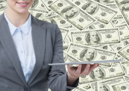 Digital composite of Business woman mid section with tablet against money backdropの写真素材