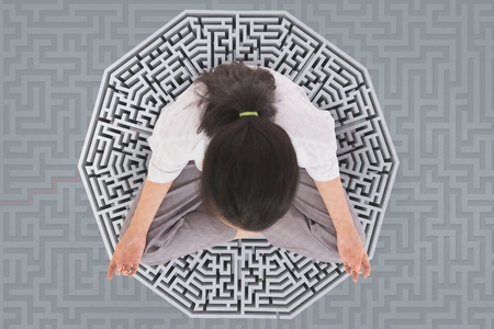 Digital composite of Woman meditating on a 3D mazeの写真素材