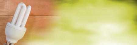 Digital composite of Light bulb on table and blurry green transitionの写真素材