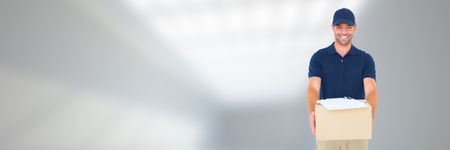 Digital composite of Delivery Courier holding box in front of blurred backgroundの写真素材