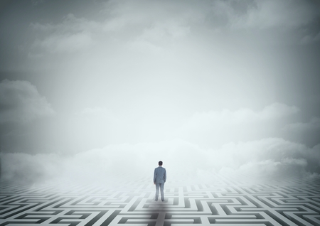 Digital composite of Man standing on a 3D maze with cloudsの写真素材